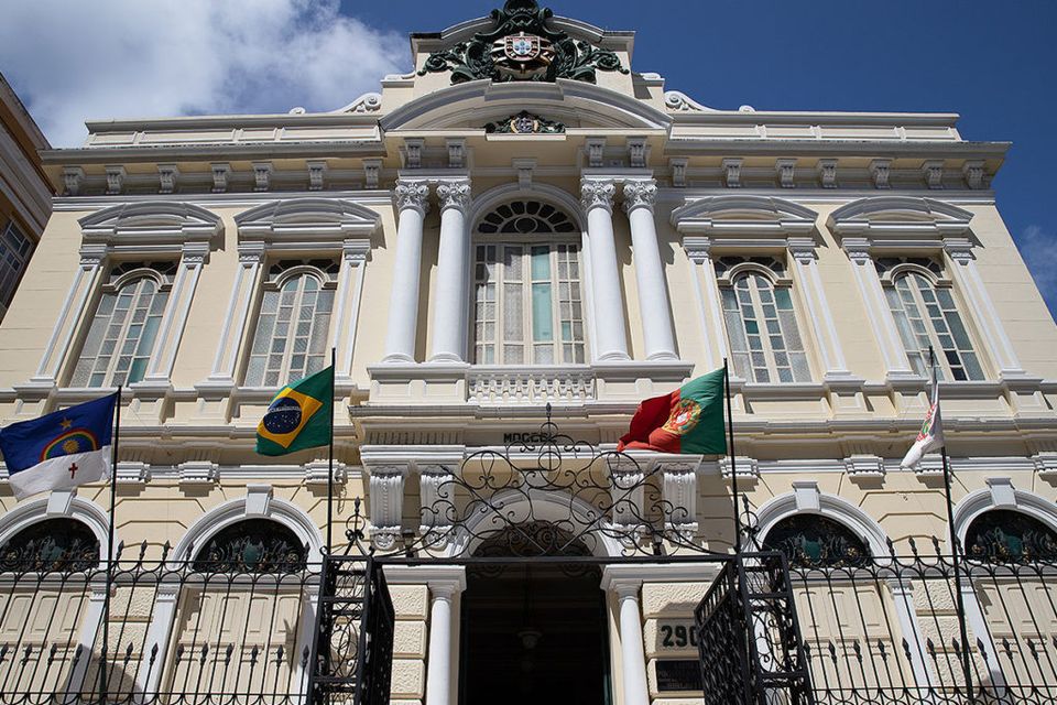 Prédio histórico com bandeiras nacionais.